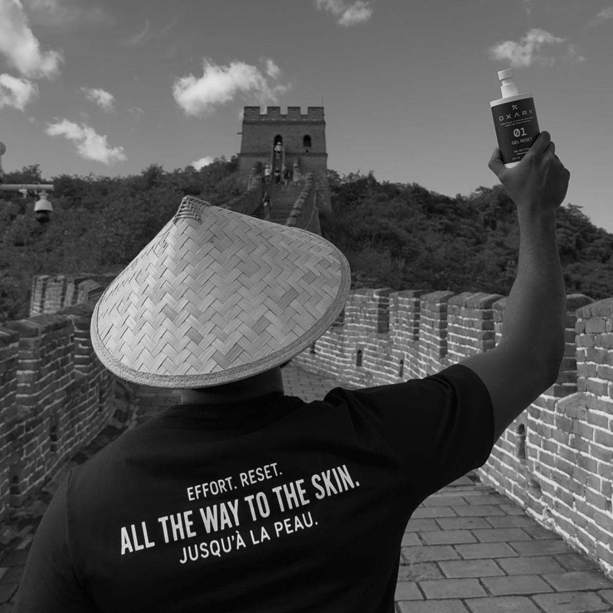 An athlete on the Great Wall of China raising a GEL RESET bottle