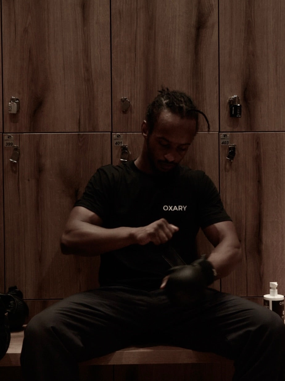 An athlete gearing up on the locker-room bench
